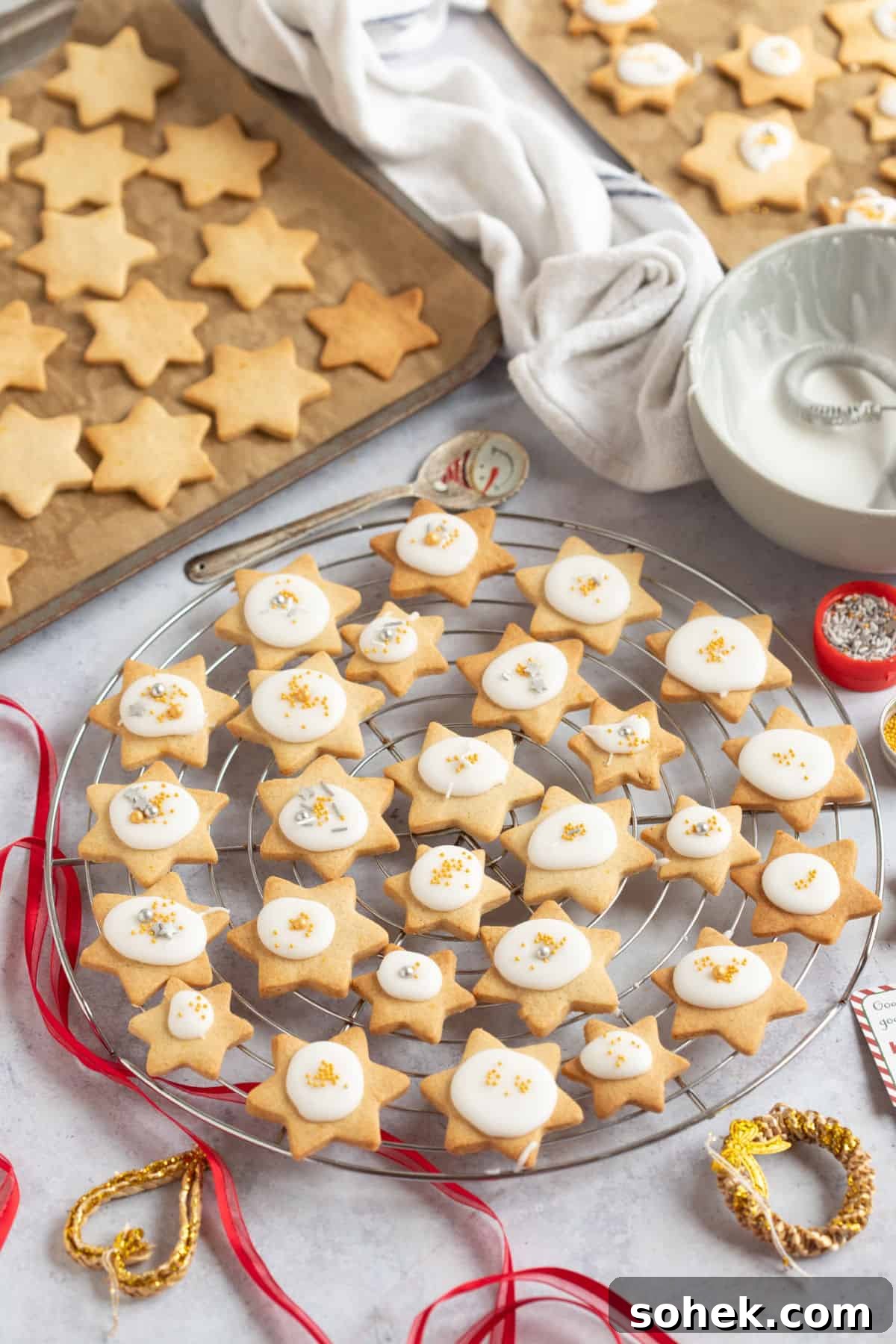 Christmas star biscuits on wire racks and baking trays.