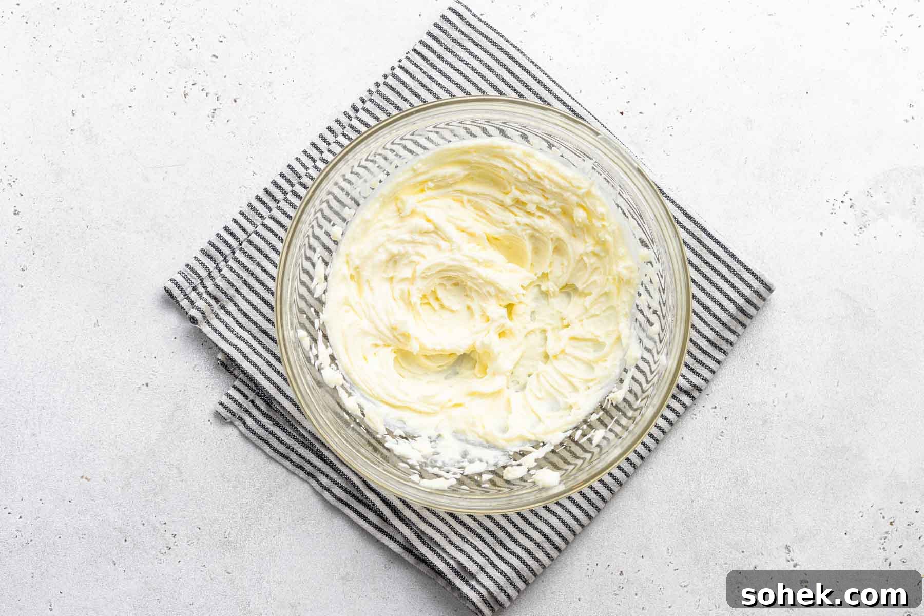 Zesty Lemon Cupcakes Recipe with Luscious Lemon Frosting 12 Lemon cream cheese frosting in clear bowl.