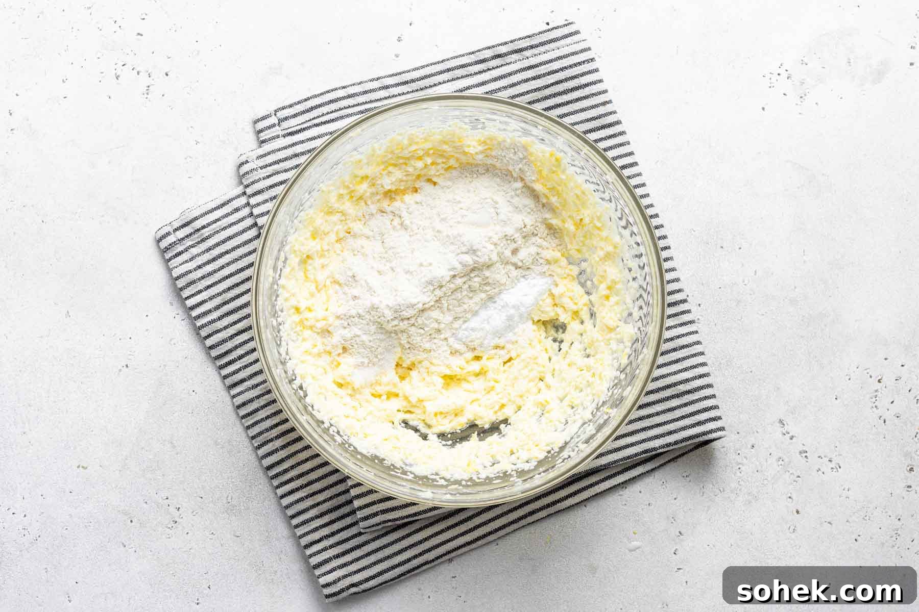 Zesty Lemon Cupcakes Recipe with Luscious Lemon Frosting 8 Lemon cupcake batter in bowl with dish towel.