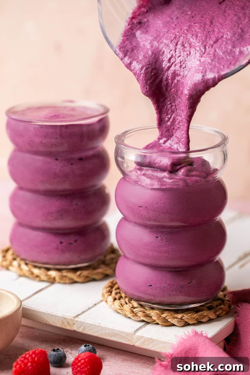 pouring a cheesecake cottage cheese smoothie into a tall glass
