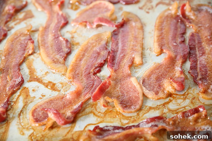 A cookie sheet full of oven-baked thick slices of bacon.