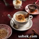 Warm milk pudding in a cup topped with nuts and ground cinnamon.