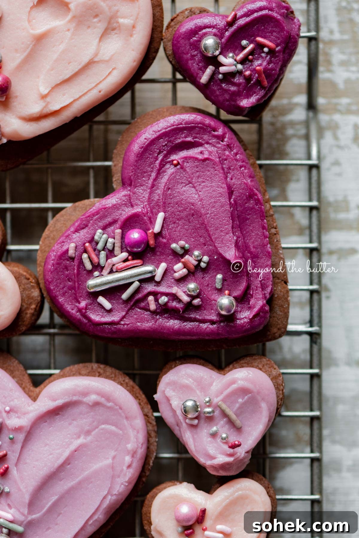 Chocolate Cut-Out Cookies: Decadent Cocoa Sugar Cookies for Decorating 5 Closeup of decorated chocolate cut out sugar cookies on a wire cooling rack on light wood colored background | All Images © Beyond the Butter®