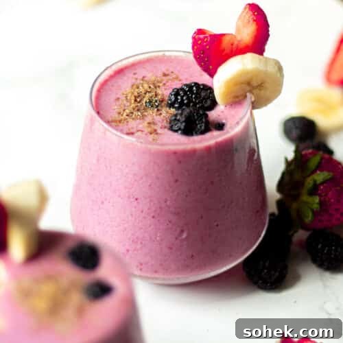 blackberry strawberry banana smoothie in a class with fruit garnish