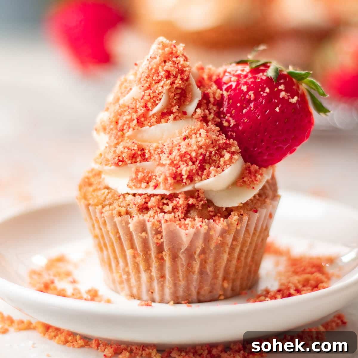 Strawberry Crunch Cupcakes Recipe with Crispy Topping 5 Sumptuous strawberry crunch cupcakes garnished with fresh strawberries and a dusting of crumbs, exuding homemade charm.