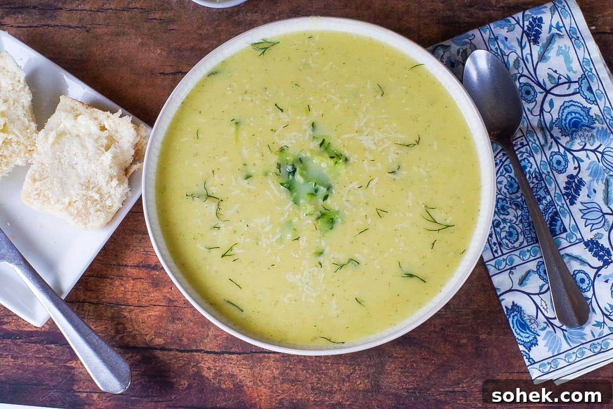 Zucchini and Potato Soup with Fresh Dill Recipe 2 Zucchini Potato soup in a beige bowl with blue paisley napkin and spoon on the side