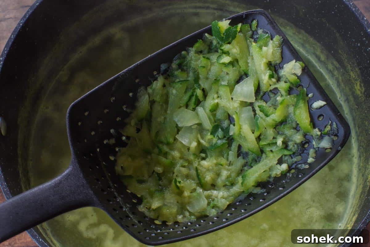 Zucchini and Potato Soup with Fresh Dill Recipe 5 vegetables being strained with a strainer scoop
