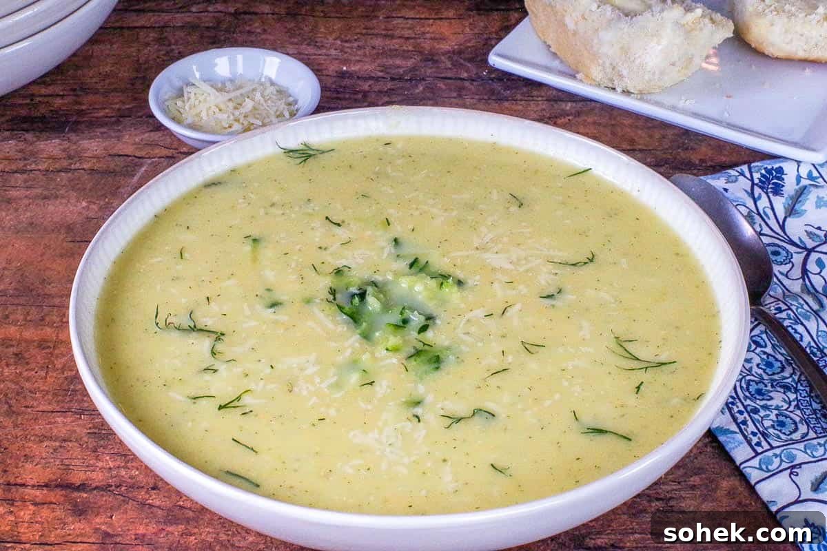 Zucchini and Potato Soup with Fresh Dill Recipe 9 Bowl of zucchini potato soup with garnishes and small white dish of parmesan cheese in the background