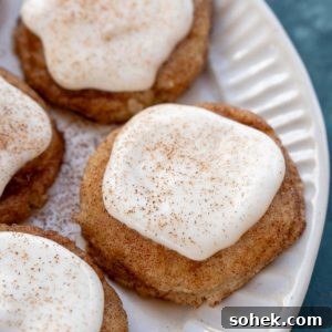 a white plate with frosted snickerdoodle cookies