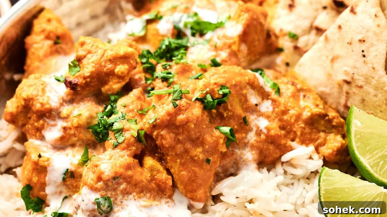 33 Quick Chicken Dinners for Busy Nights When You’re Tired but Hungry 23 A close-up of chicken tikka masala served on rice, garnished with fresh cilantro, with lime wedges and naan on the side.