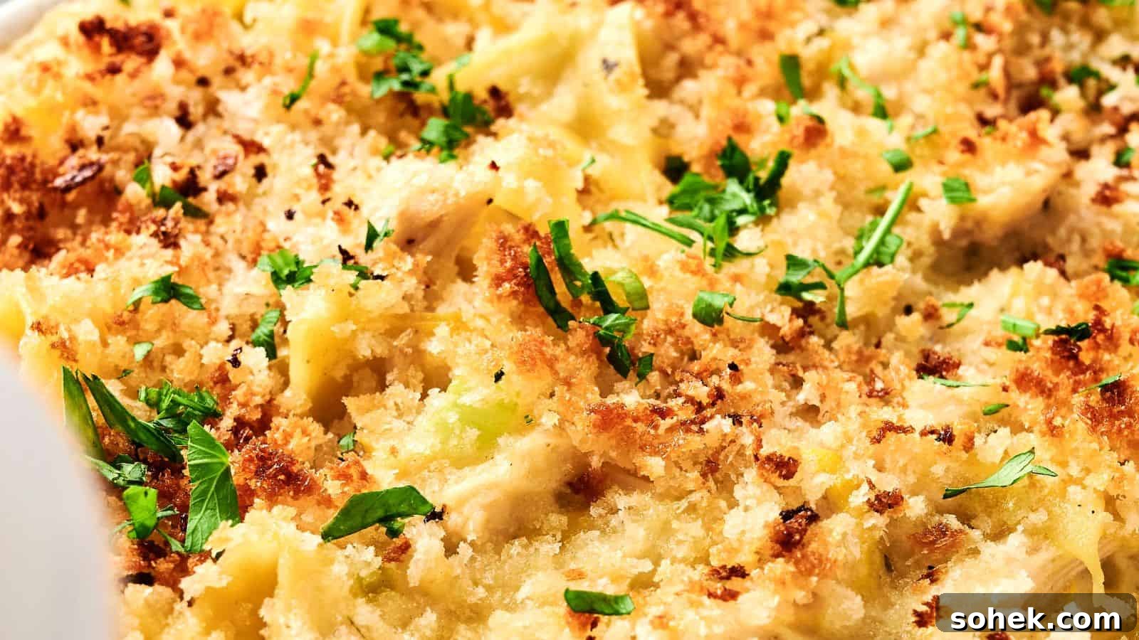 33 Quick Chicken Dinners for Busy Nights When You’re Tired but Hungry 27 Close-up of a chicken noodle casserole with a golden breadcrumb topping, garnished with chopped herbs.