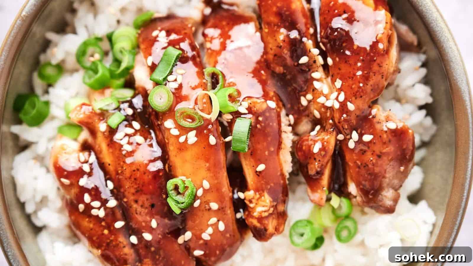 33 Quick Chicken Dinners for Busy Nights When You’re Tired but Hungry 33 A bowl of white rice topped with glazed chicken and garnished with green onions and sesame seeds.