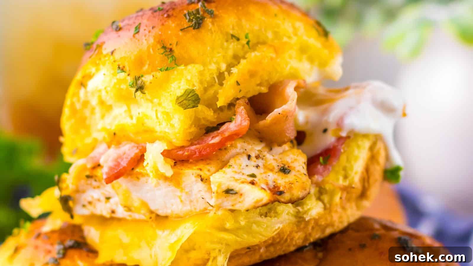 33 Quick Chicken Dinners for Busy Nights When You’re Tired but Hungry 8 Close-up of chicken bacon ranch sliders with grilled chicken, bacon, and melted cheese inside a golden bun, garnished with herbs.