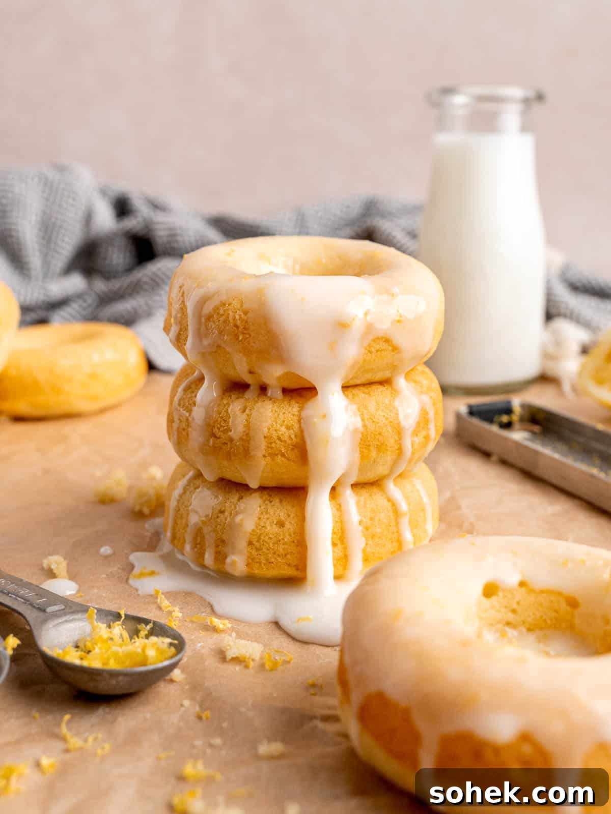 A stack of baked lemon donuts with icing.