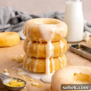 A stack of baked lemon donuts with icing.