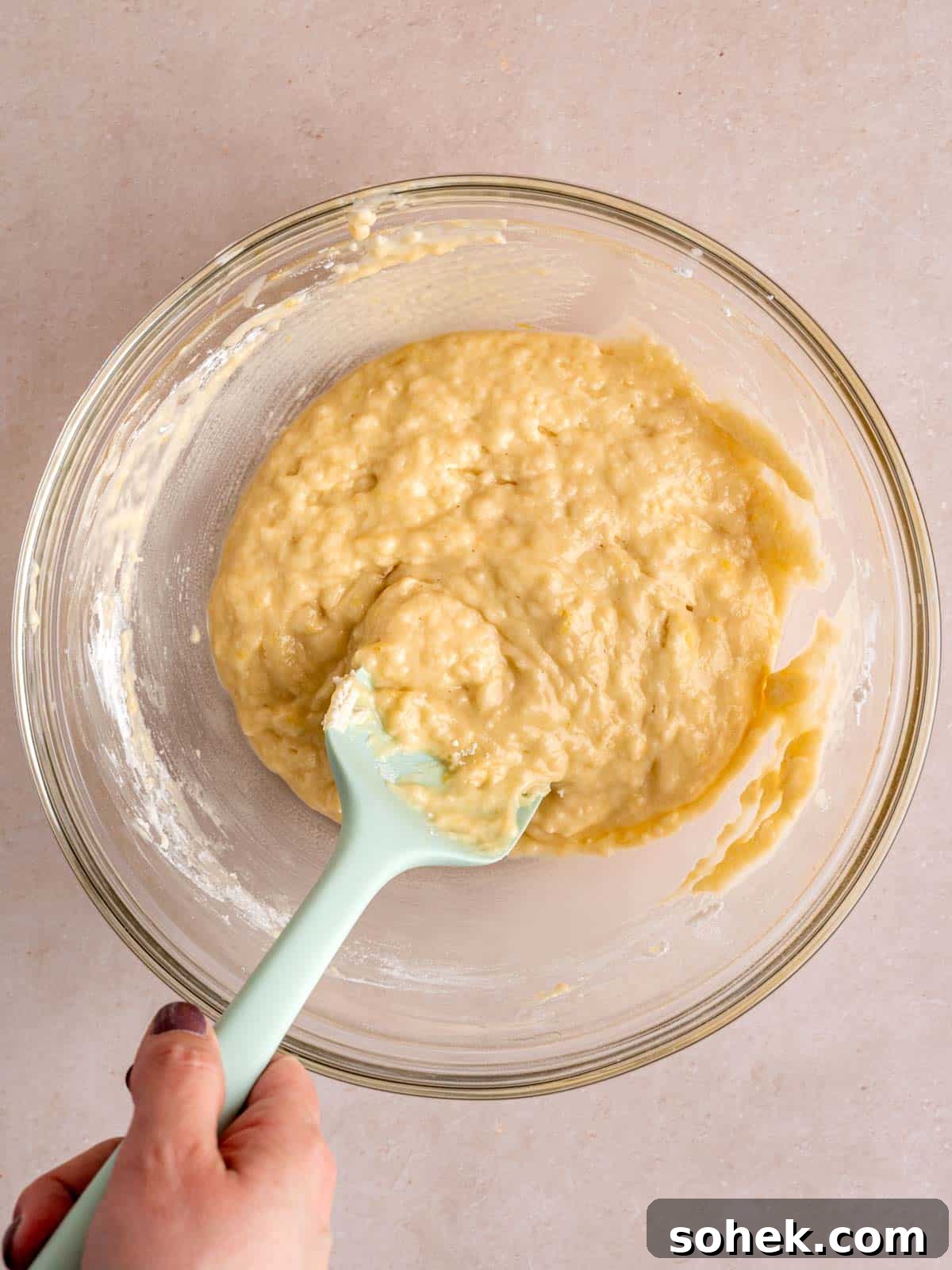 Lemon donut batter in a bowl with a spatula.