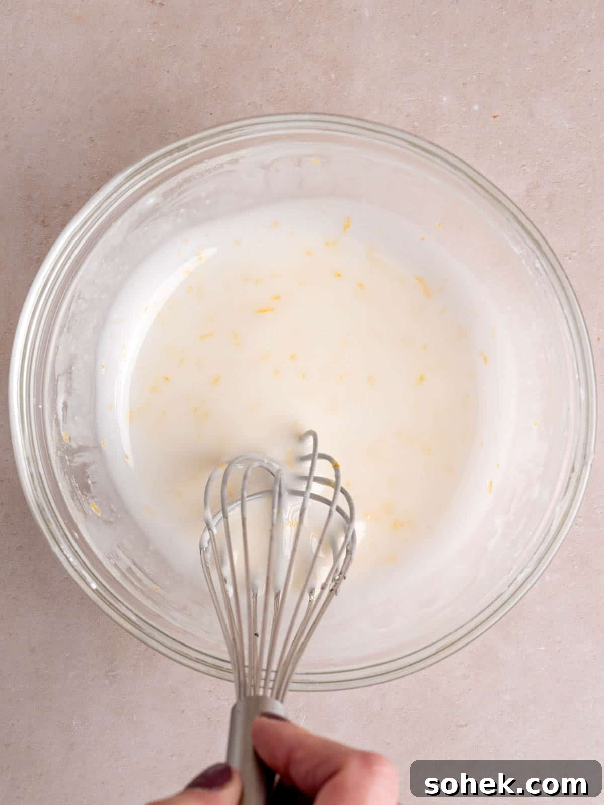 Whisking lemon flavored icing in a bowl.