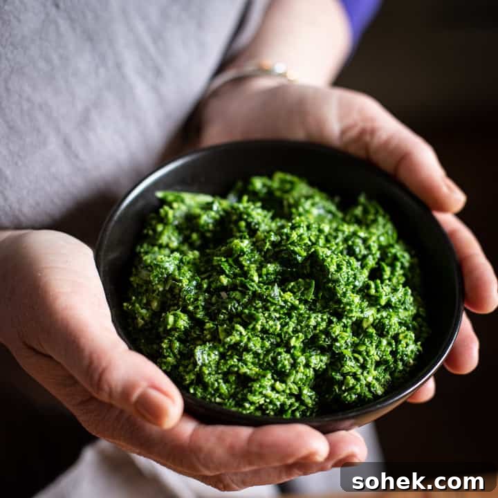Wild Garlic Pesto: Simple Spring Sauce Recipe for Pasta & Bread 4 womans hands holding a small black bowl of wild garlic pesto