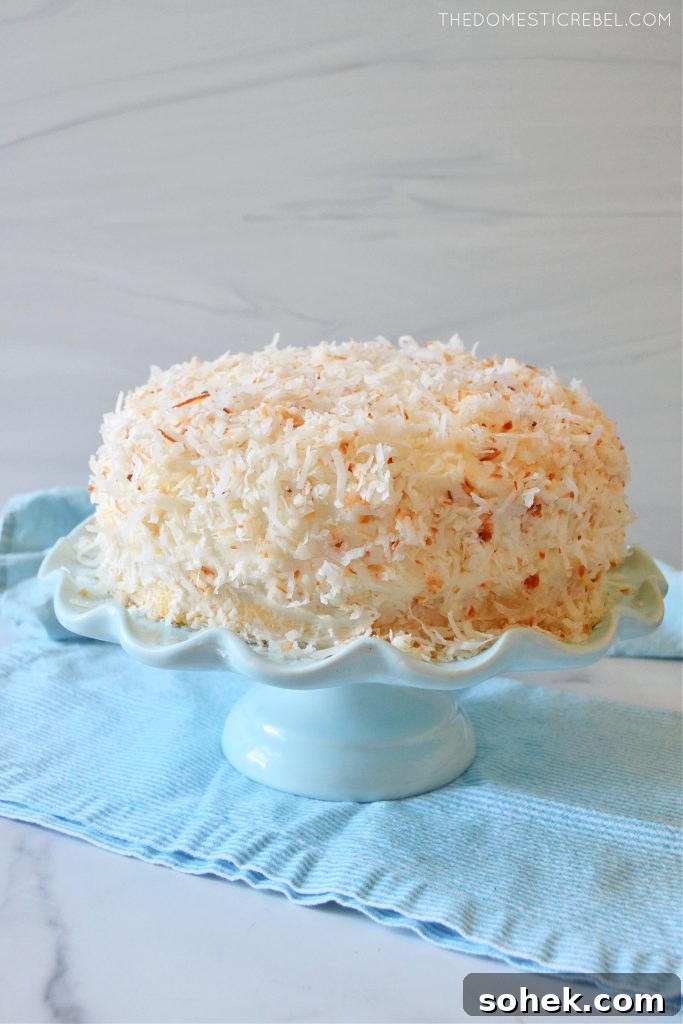 coconut layer cake on a blue cake stand