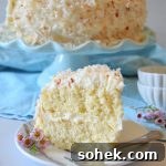 a slice of coconut layer cake on a white plate
