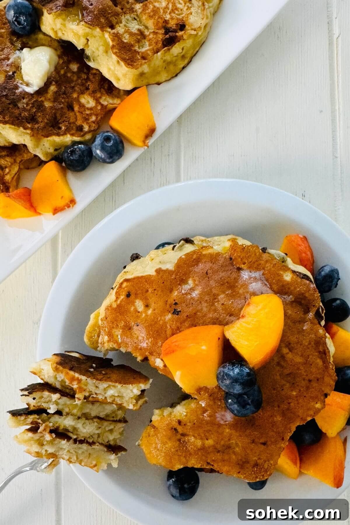 Fluffy Banana and Cottage Cheese Pancakes for Protein-Packed Breakfast 3 Stack of cottage cheese pancakes with a bite on a fork.