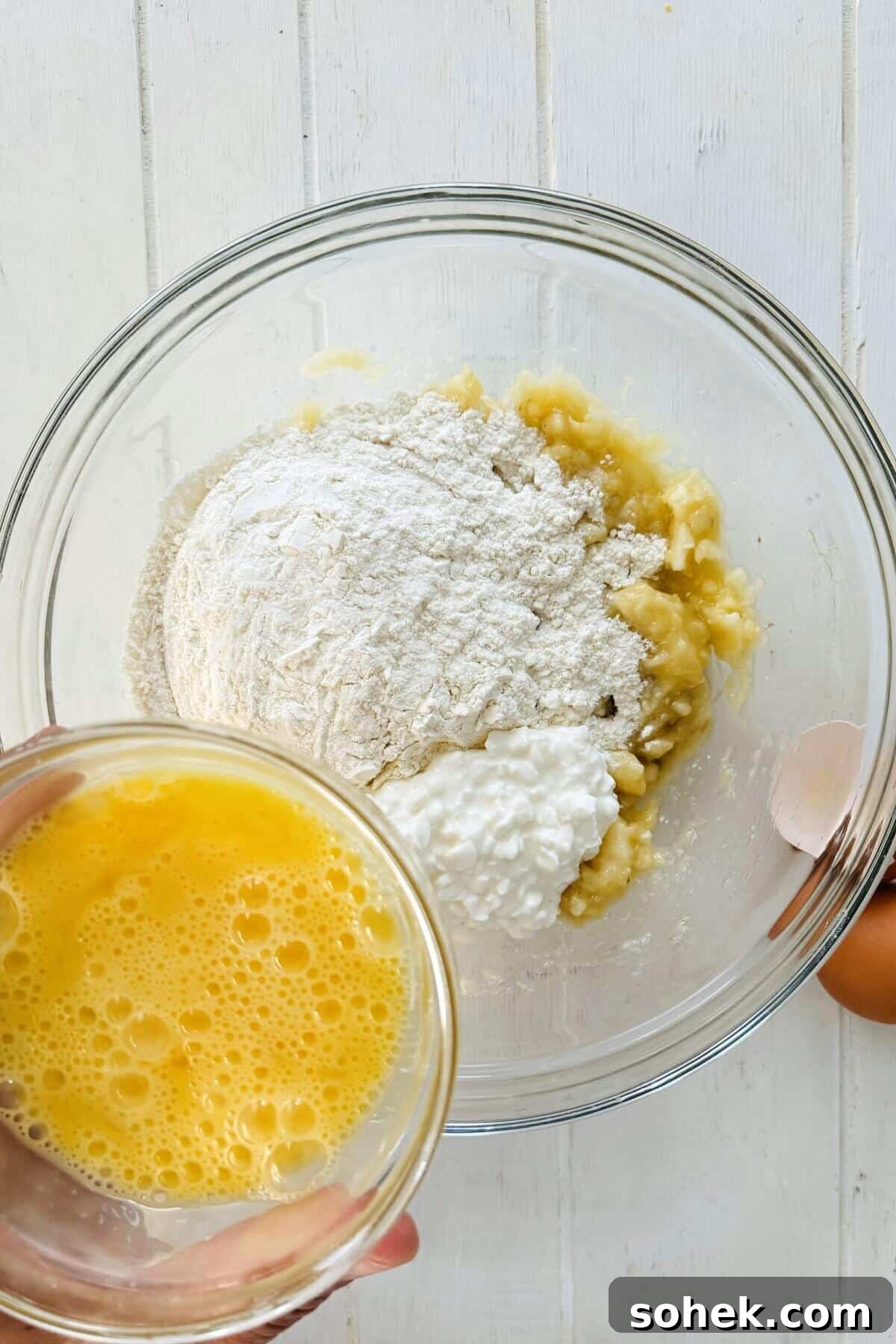 Fluffy Banana and Cottage Cheese Pancakes for Protein-Packed Breakfast 6 Adding eggs to flour and mashed bananas.