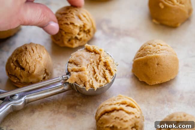 peanut butter cookie dough in balls and dough in a cookie scoop.