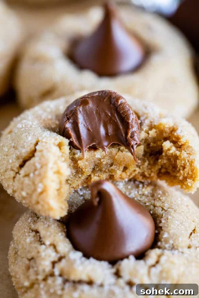 half a peanut butter blossom cookie stacked on another cookie.