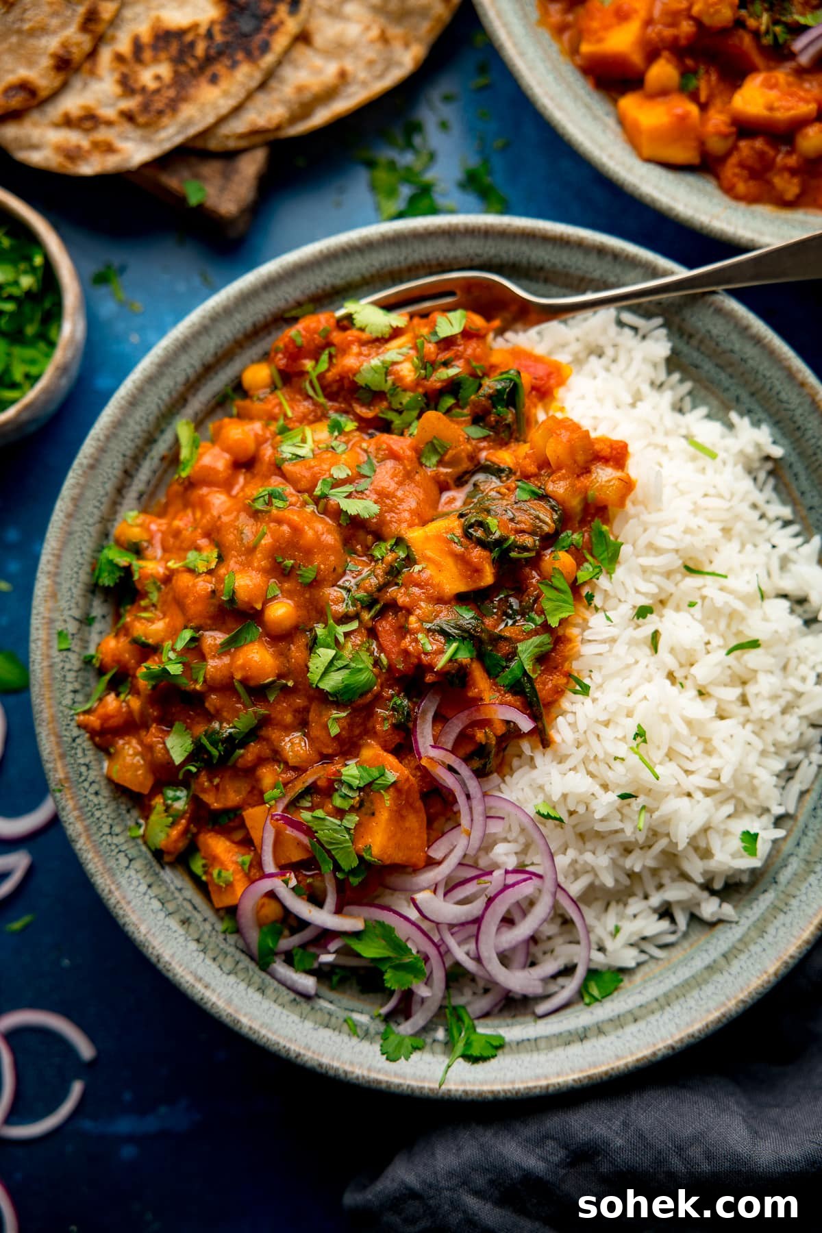 chickpea and sweet potato curry with rice in a green bowl
