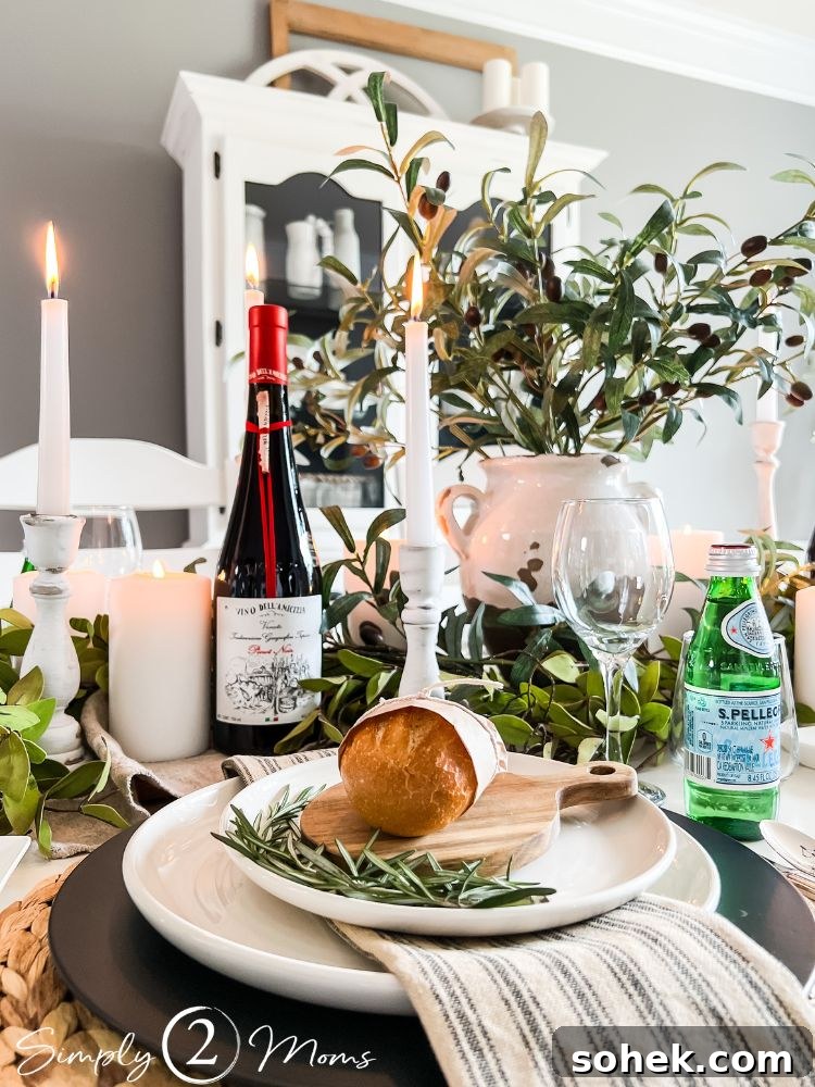 Stunning Italian Dinner Party Menu Ideas to Impress Your Guests 9 A plate with rosemary, dinner roll, and linen napkin on table decorated with candles, olive stems, and a wine bottle