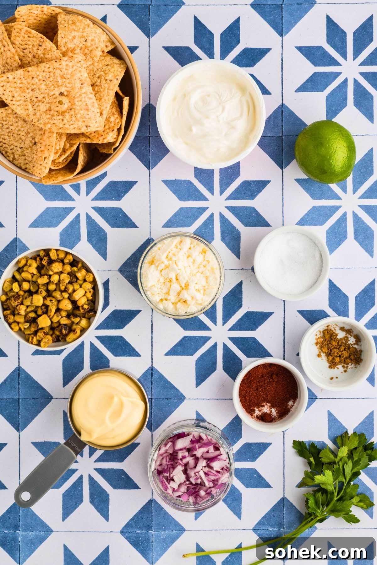 Ingredients measured into small bowls on a blue and white tiled table. 