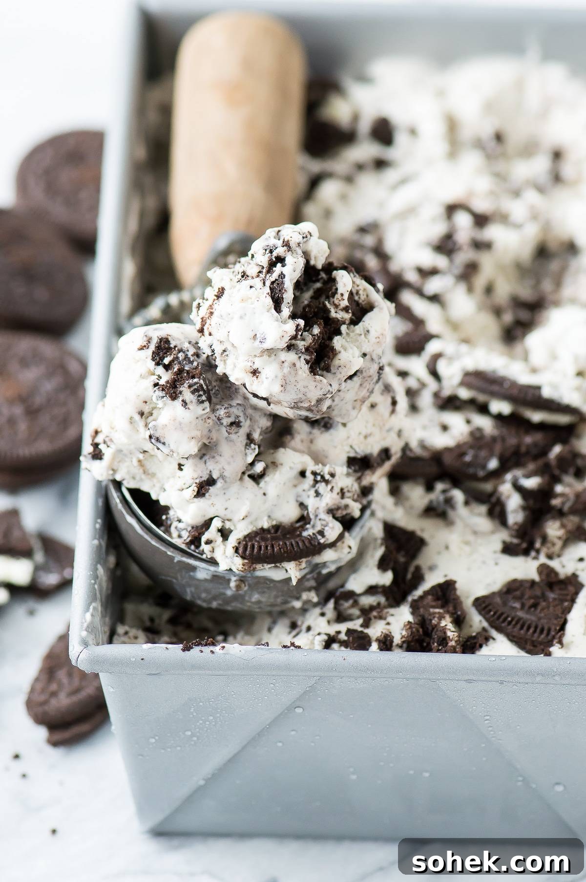 3 ingredient Oreo Ice Cream - the easiest no churn oreo ice cream recipe! Scooping easy Oreo Ice Cream out of a metal loaf pan