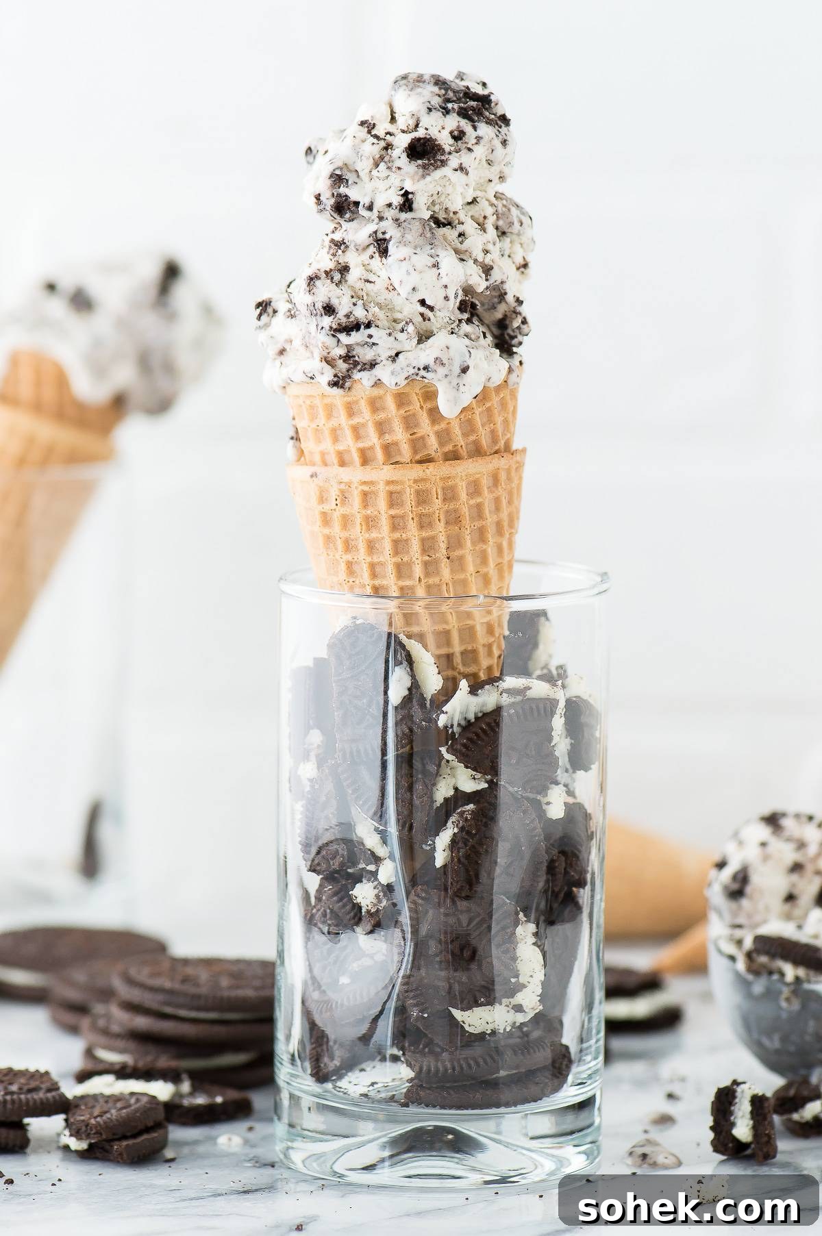3 ingredient Oreo Ice Cream - the easiest no churn oreo ice cream recipe! 3 Ingredient Oreo Ice Cream in two waffle cones inside of a glass full of broken oreos.
