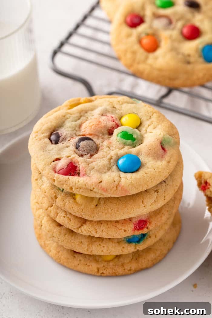 Chewy M&M Cookies Recipe for Perfect Chocolate Crumble 11 5 m&M cookies stacked on a white plate.