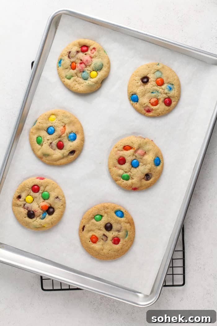 Chewy M&M Cookies Recipe for Perfect Chocolate Crumble 8 6 baked m&m cookies on a parchment-lined baking sheet.
