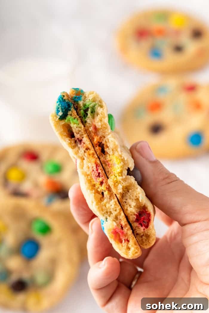 Chewy M&M Cookies Recipe for Perfect Chocolate Crumble 10 M&M cookie broken in half and being held up to the camera.