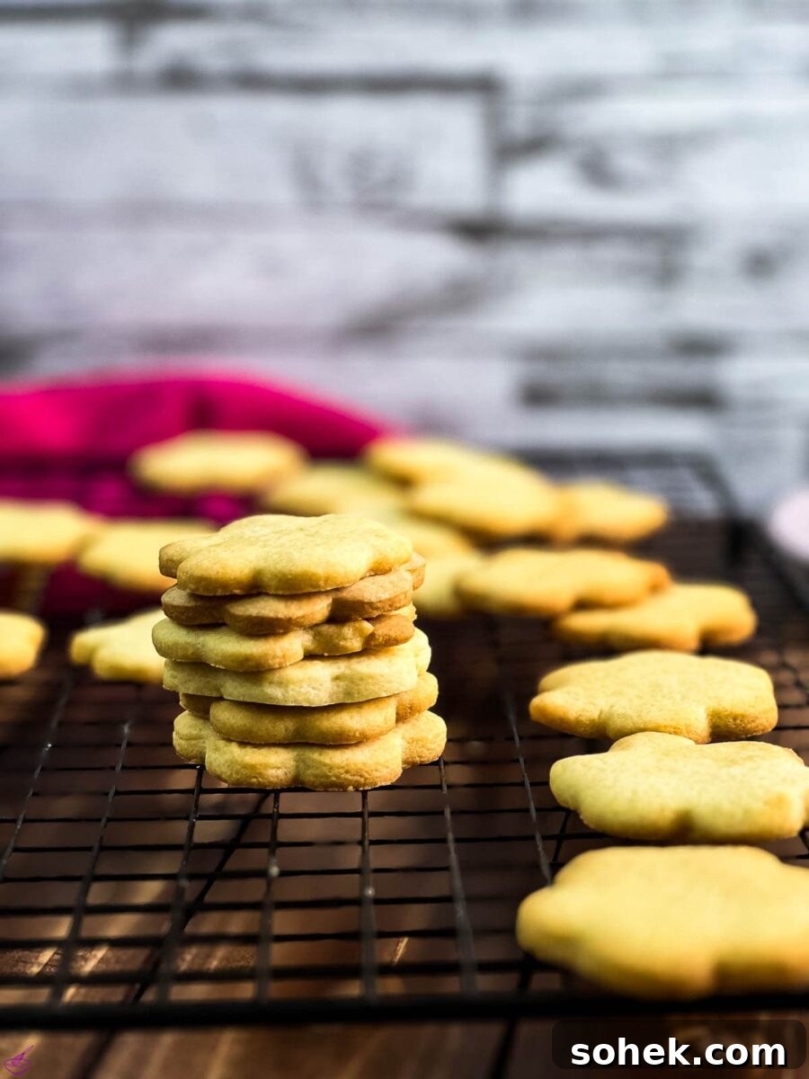 No-Chill Cut-Out Sugar Cookies Recipe — Soft, Ready-to-Roll 8 Gorgeous sugar cookies stacked beautifully on a cooling rack.