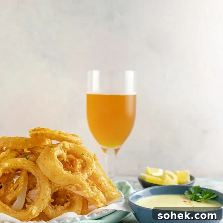 Beer Battered Old Bay Onion Rings with Creamy Lemon Dipping Sauce - An appetizer or side dish that's boardwalk ready, no matter where you are!