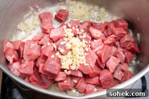 Greggs-Style Steak Bake Recipe: How to Make It at Home 8 Chopped stewing steak, chopped garlic added to the fried chopped onion in a cooking pot