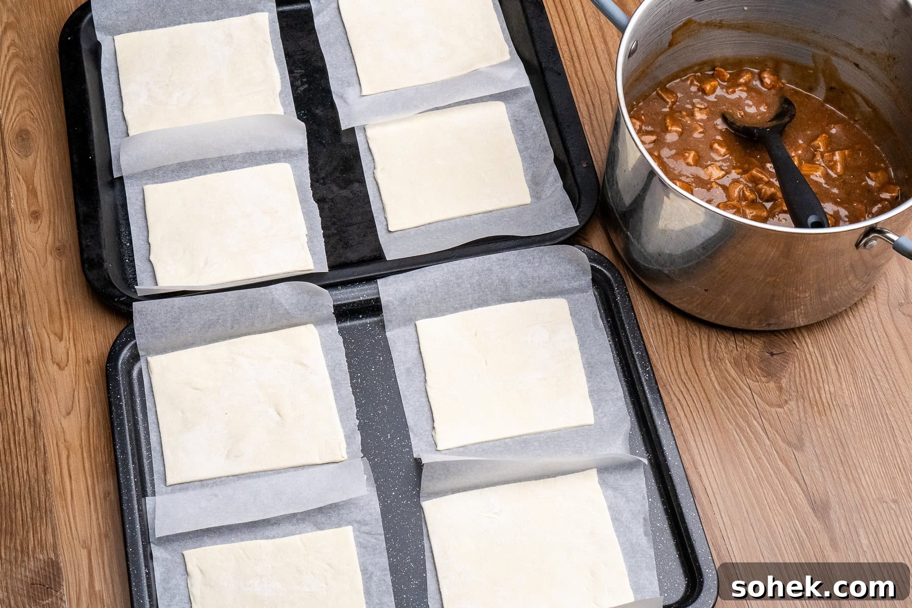 Greggs-Style Steak Bake Recipe: How to Make It at Home 34 A large pot of steak bake filling with eight squares of puff pastry on parchment paper on two baking trays