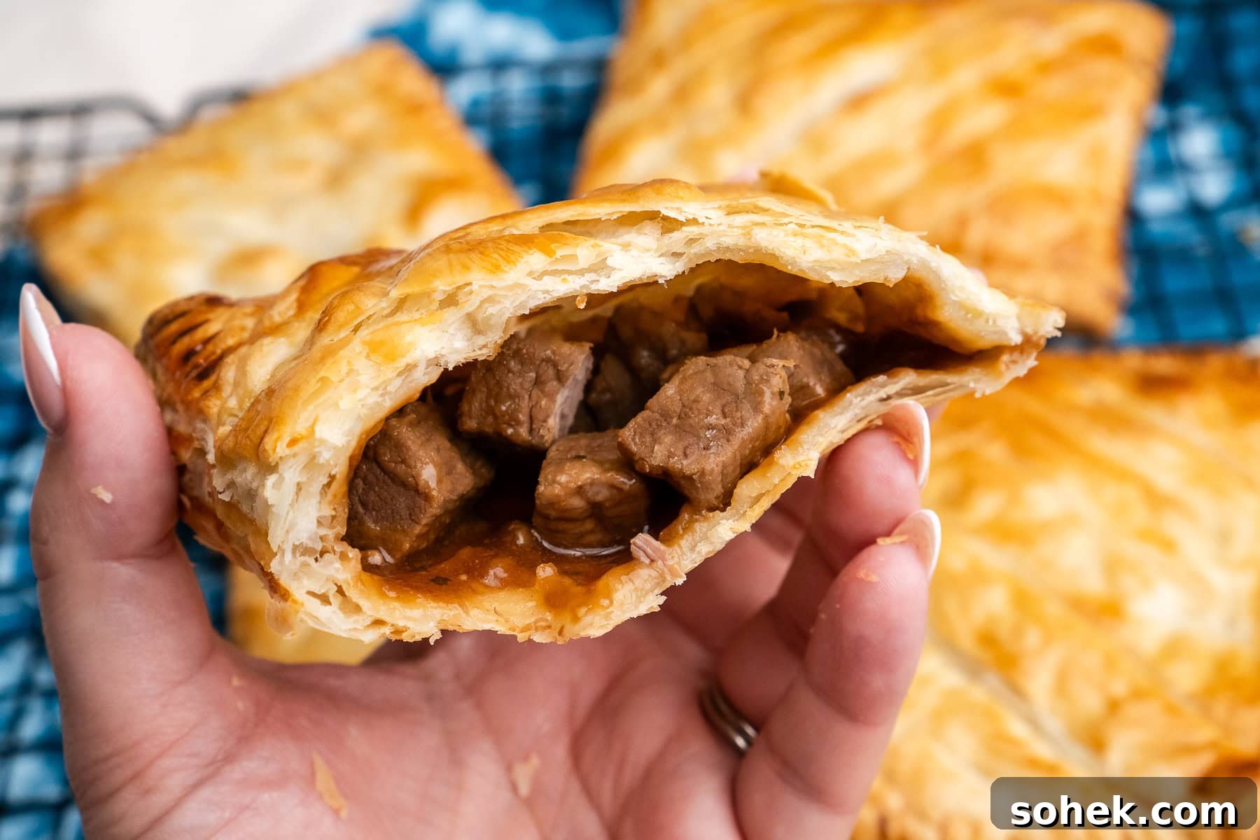 Greggs-Style Steak Bake Recipe: How to Make It at Home 44 Holding a steak bake with the steak filling showing