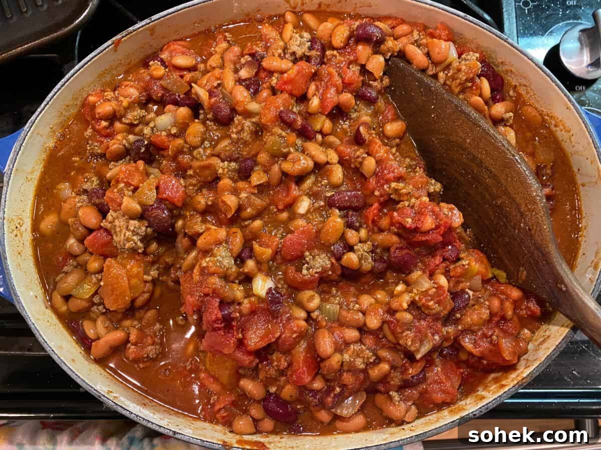Classic Idaho Chili Recipe: Hearty Potato and Beef Chili 11 A large pot of chili on the stove with a wooden serving spoon.