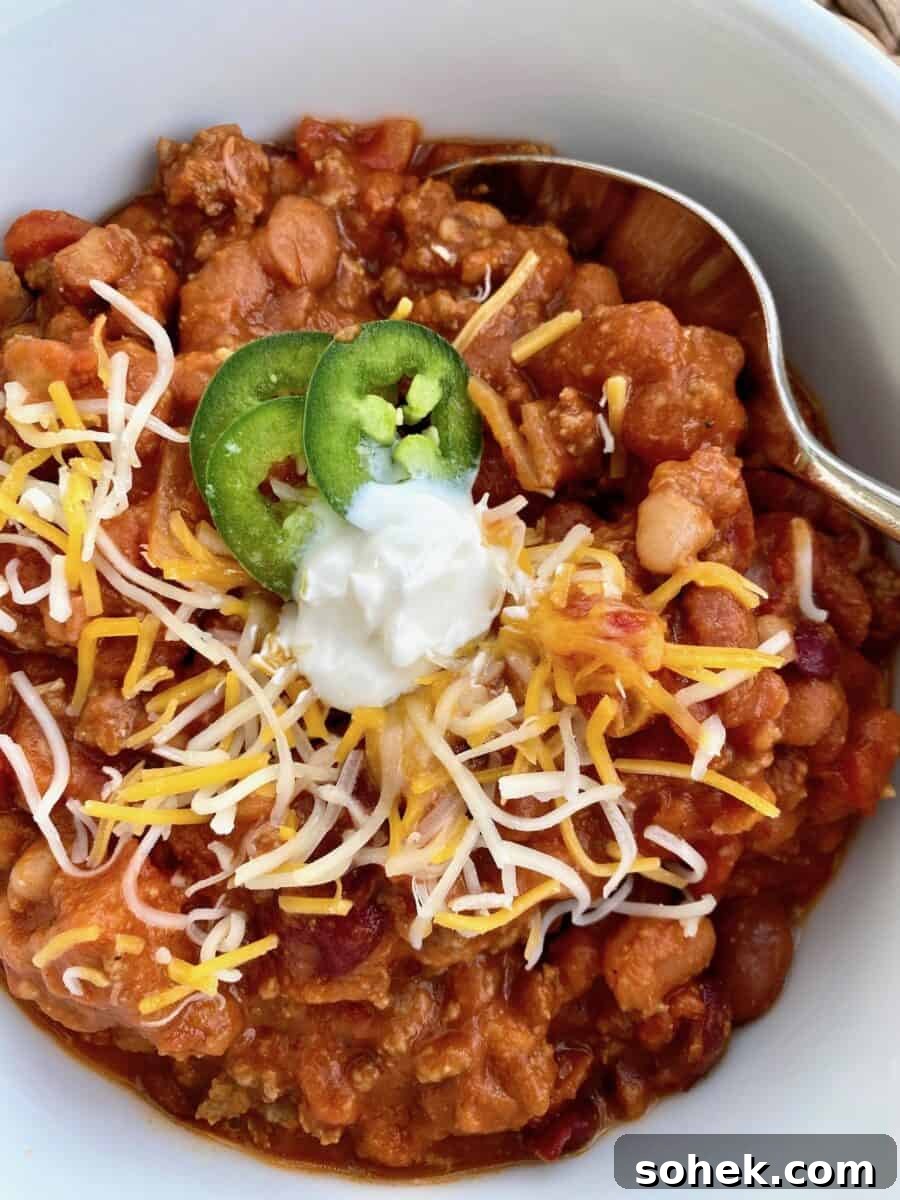 Classic Idaho Chili Recipe: Hearty Potato and Beef Chili 3 A bowl of chili with toppings and a spoon on the side