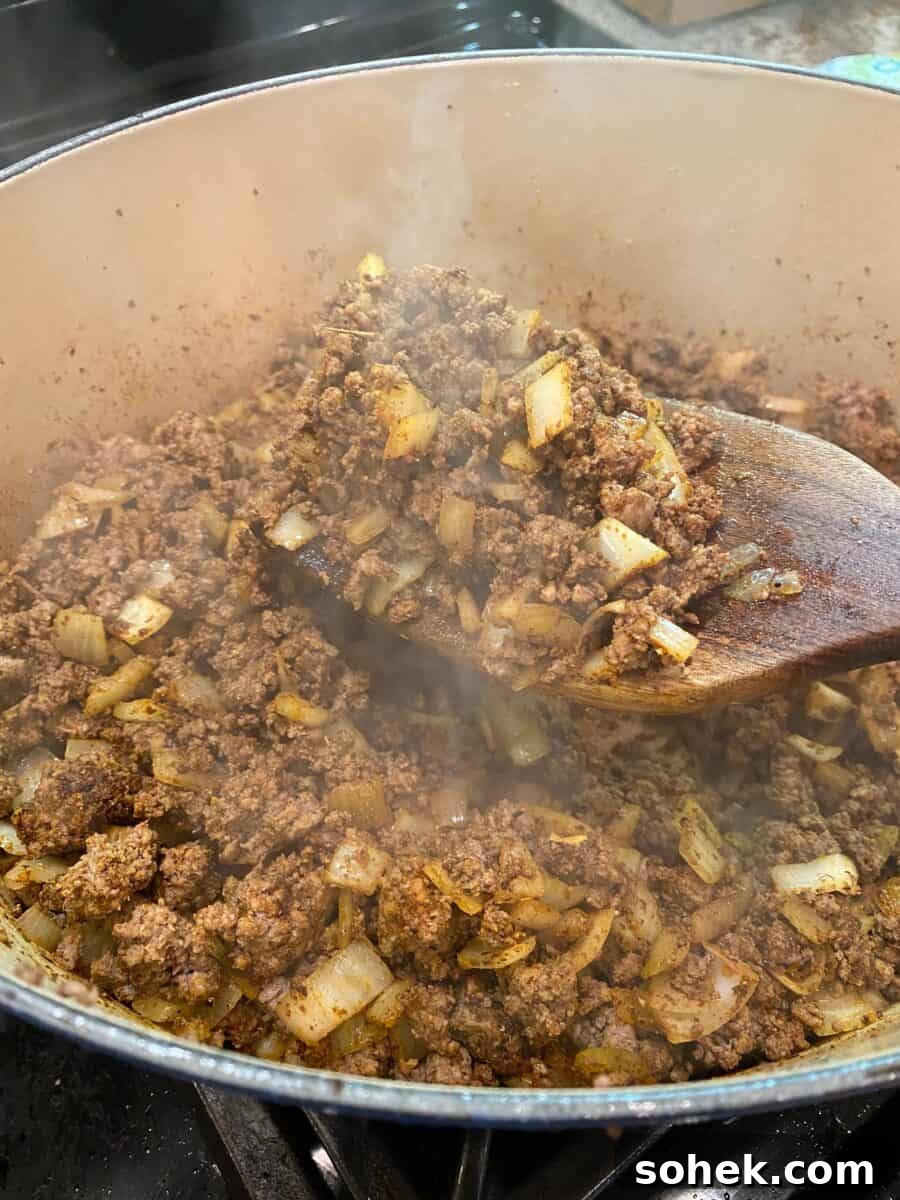 Classic Idaho Chili Recipe: Hearty Potato and Beef Chili 7 Chili meat and onions browned and steaming in a pot on the stove.