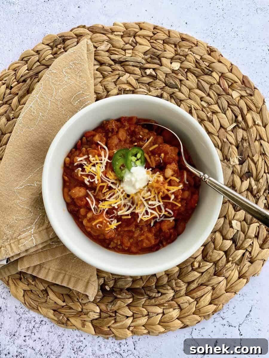 Classic Idaho Chili Recipe: Hearty Potato and Beef Chili 9 A bowl of chili on a placemat with a napkin on the side of the bowl and a spoon in the chili