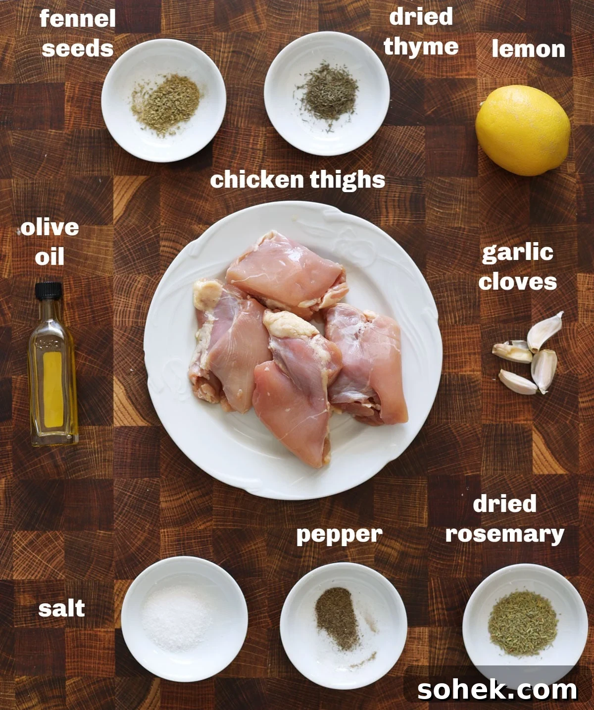 Juicy Smoked Chicken Thighs with Crispy Skin Recipe 4 Chicken thighs, herbs, lemon, and garlic clove on a counter.