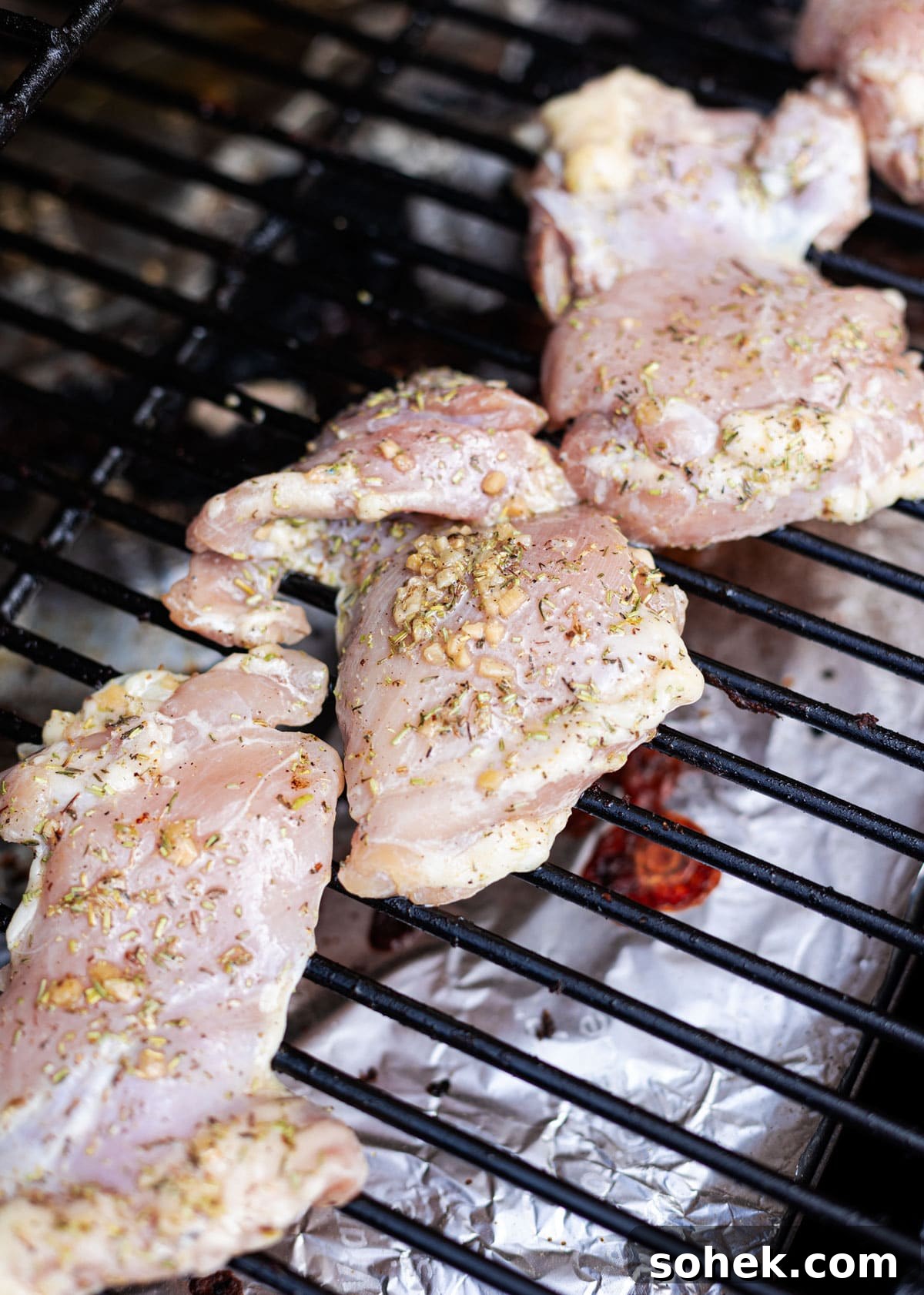 Juicy Smoked Chicken Thighs with Crispy Skin Recipe 8 Chicken thighs on a smoker grill topped with seasonings