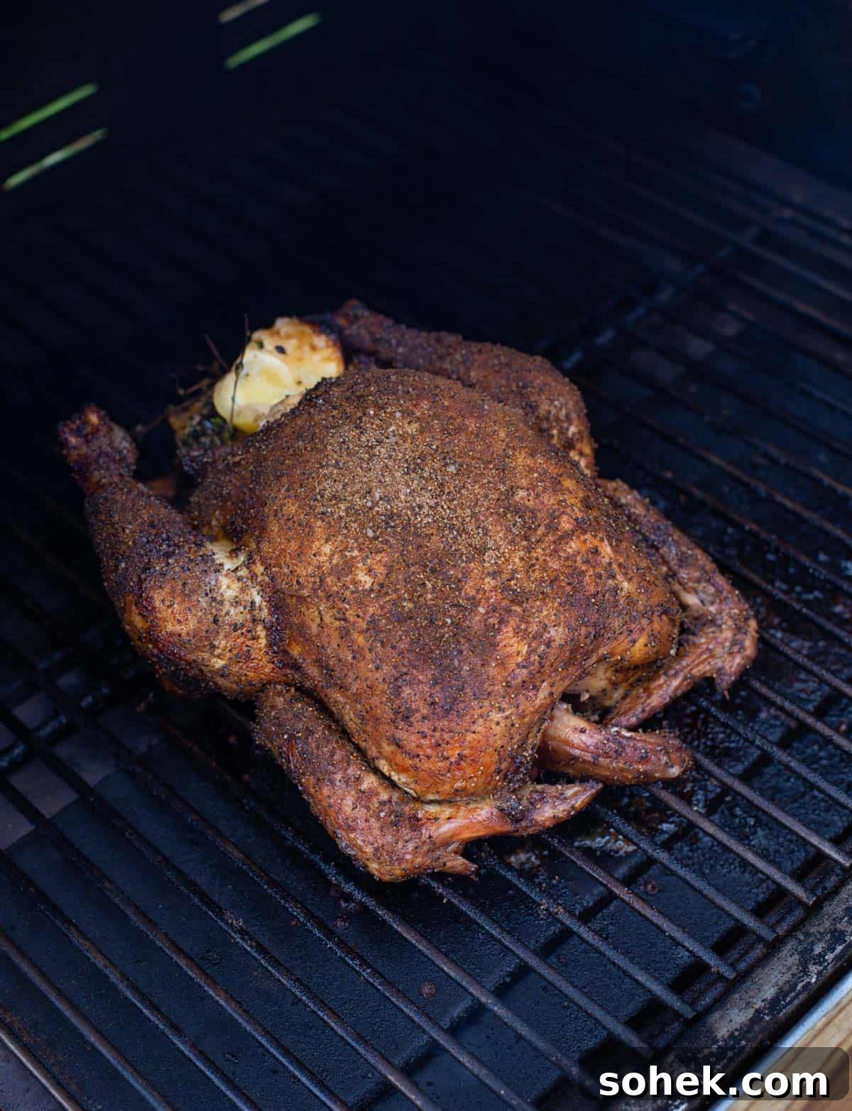 A whole chicken cooking on a pellet grill