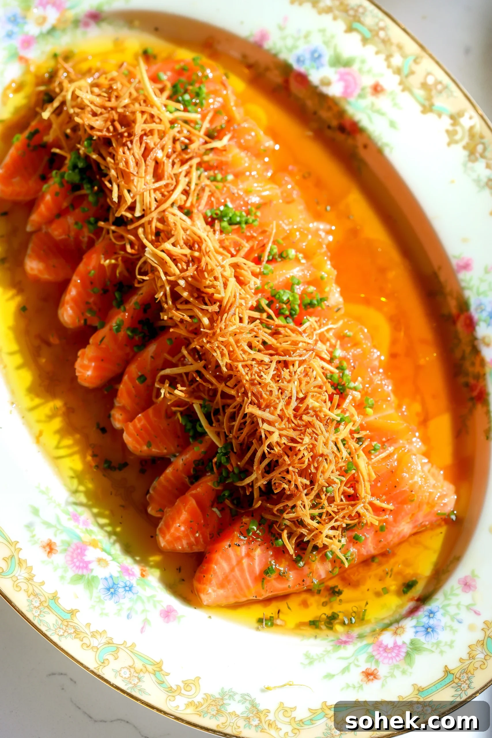 Yuzu Ponzu Salmon Crudo Recipe: Citrus-Marinated Raw Salmon 3 Overhead view of salmon crudo arranged on a platter with yuzu ponzu, crispy parsnips, and chopped chives.