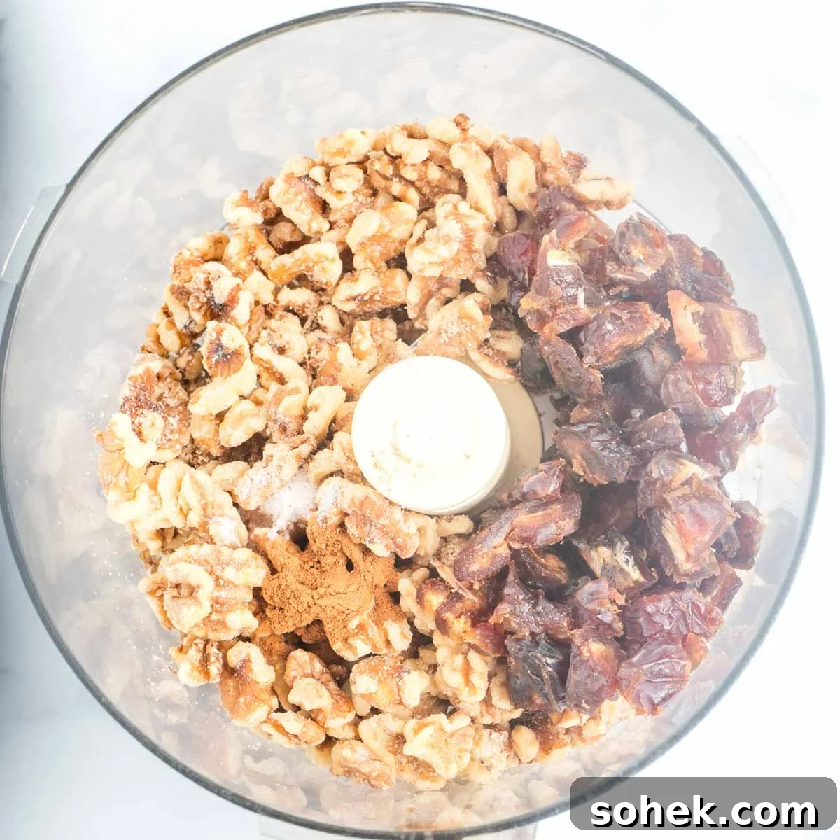 Apple Walnut Tart with Creamy Vegan Cashew Custard Recipe 6 Food processor bowl with sections of walnuts, chopped dates, cinnamon and salt.